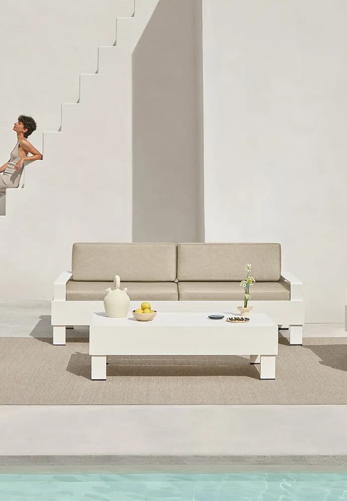 White Zenttal table and sofa on a terrace by the pool