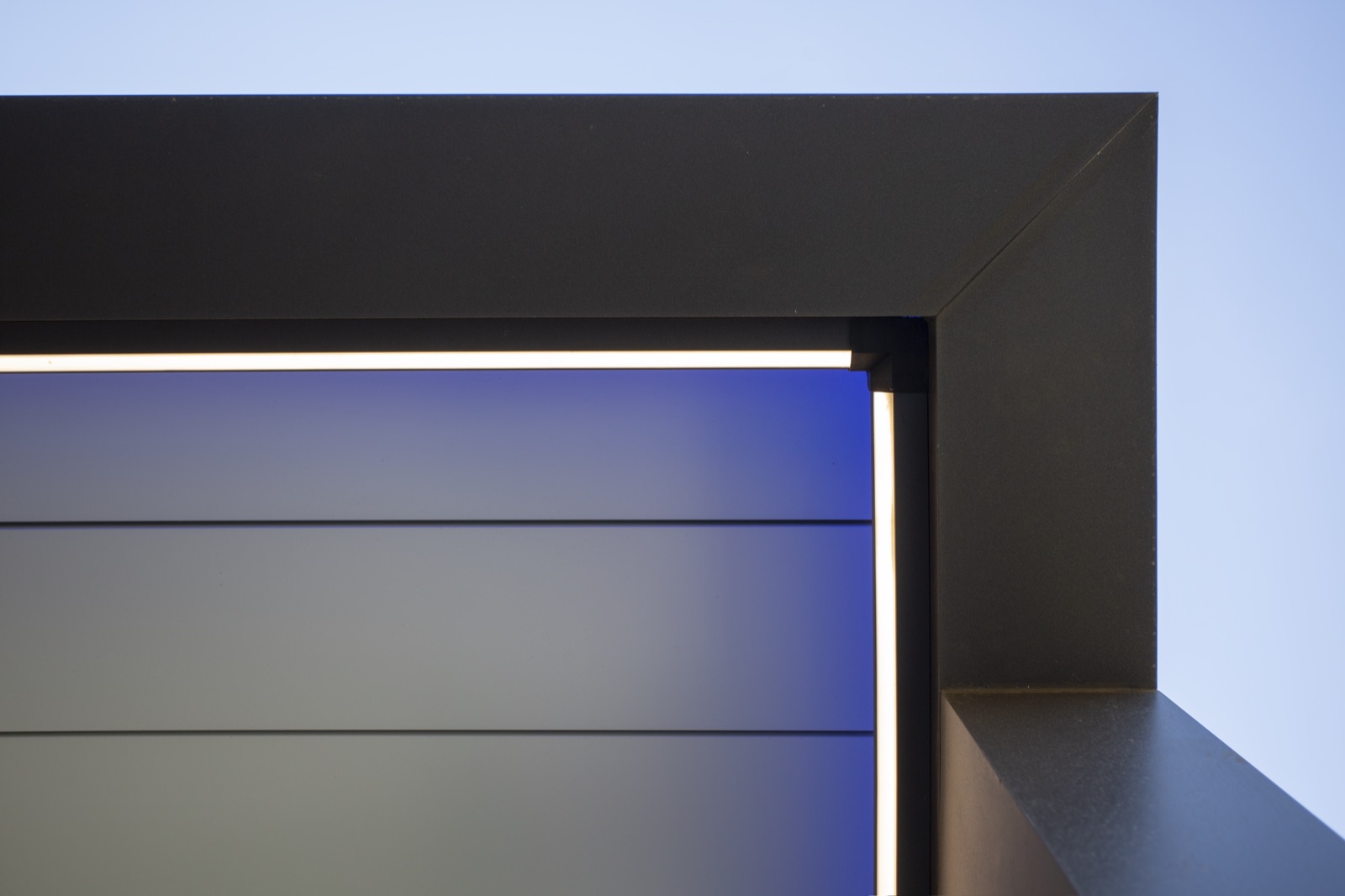 LED strip lit around the edge of a dark pergola, in blue light